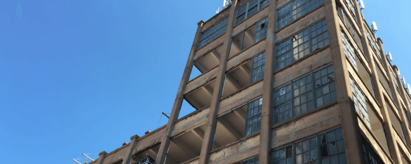 Half-finished, tall building is photographed from an upward angle.
