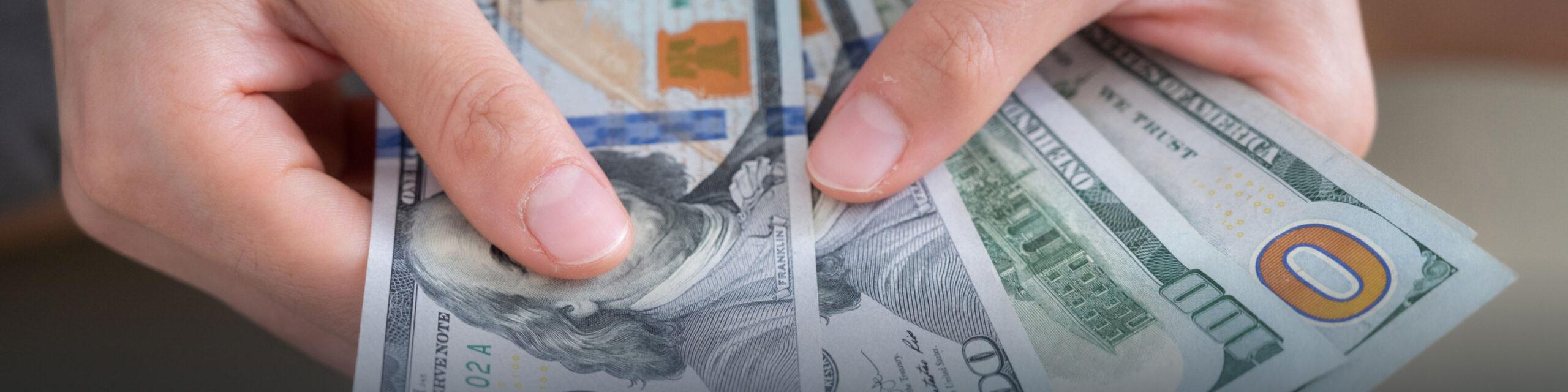 A person is holding 4 $100 bills.